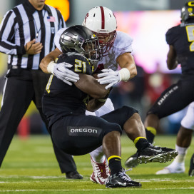 Senior inside linebacker Blake Martinez (rear) wraps up a tackle against Oregon's Royce Freeman (front) in last year's 45-16 drubbing of the Cardinal by the Ducks in Eugene. (JIM SHORIN/stanfordphoto.com)