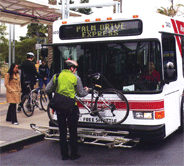 Biker lifting bike onto bus bike rack