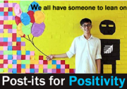 boy standing in front of wall with colorful post its