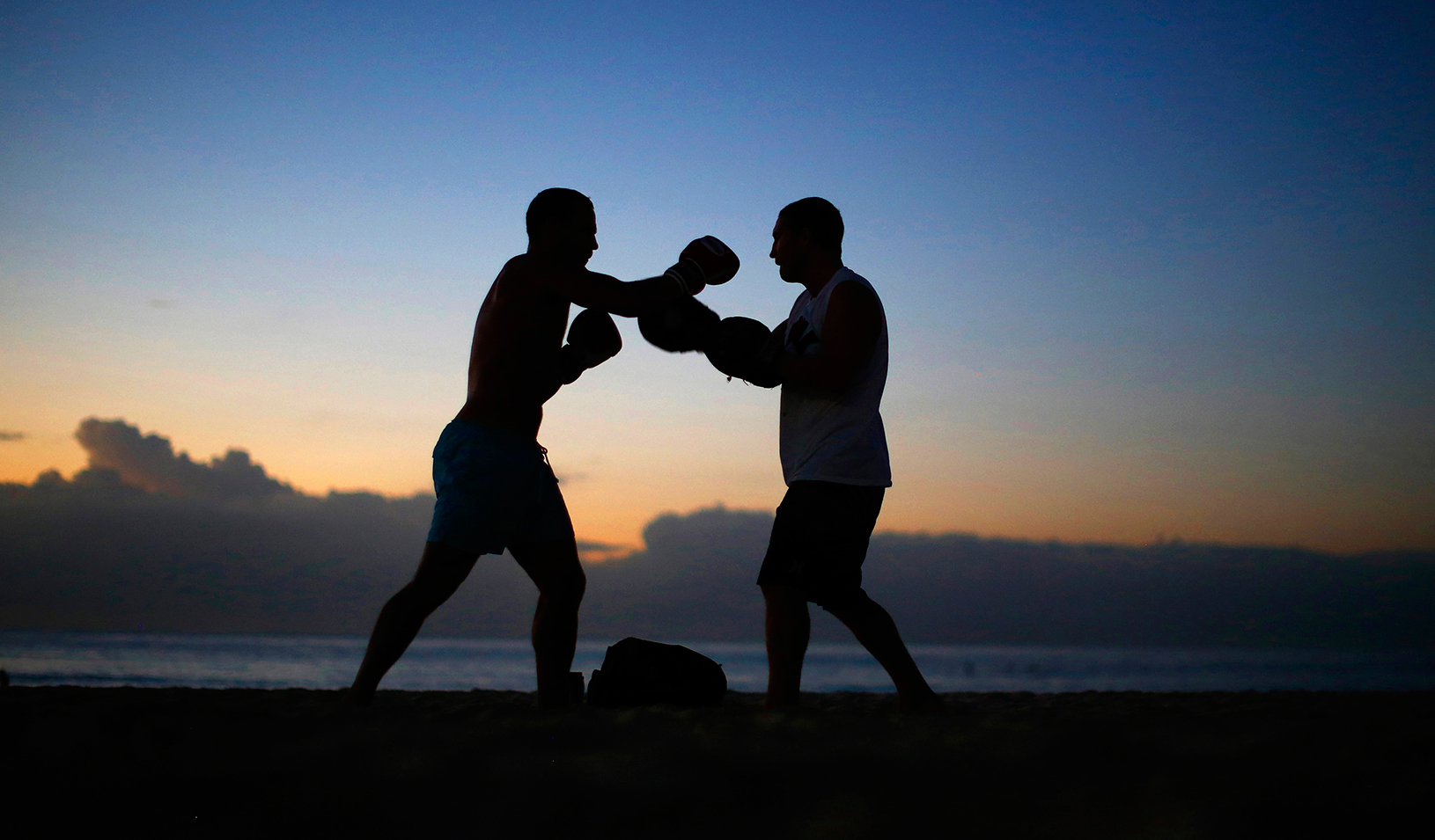 Two boxers sparing outside at dusk