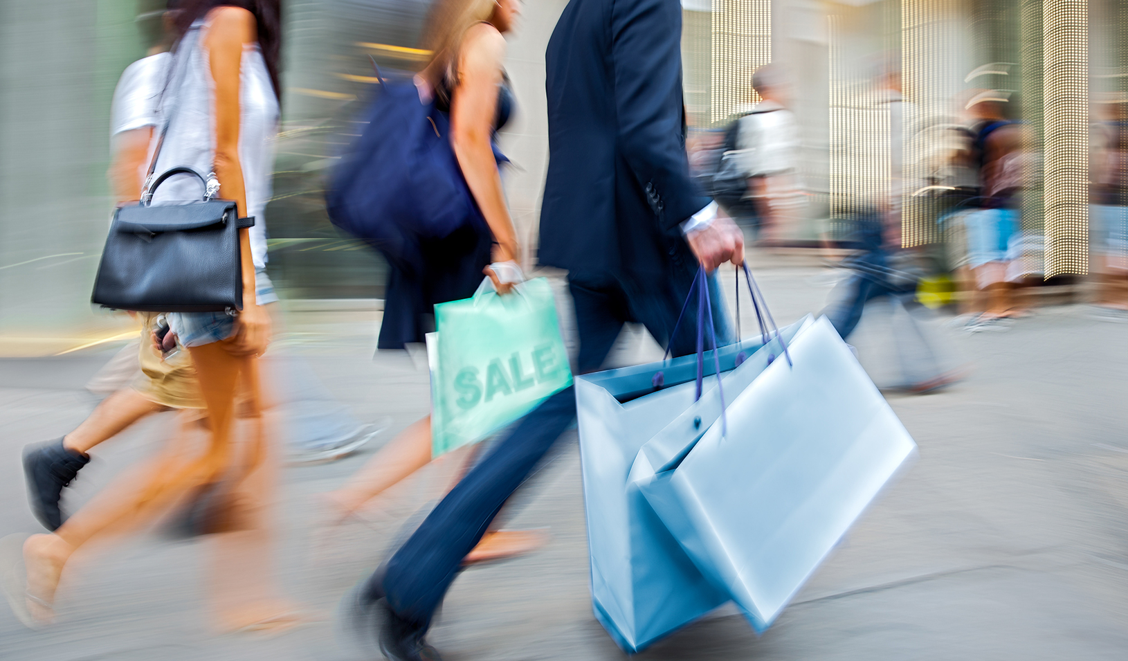 individuals walking with shopping bags