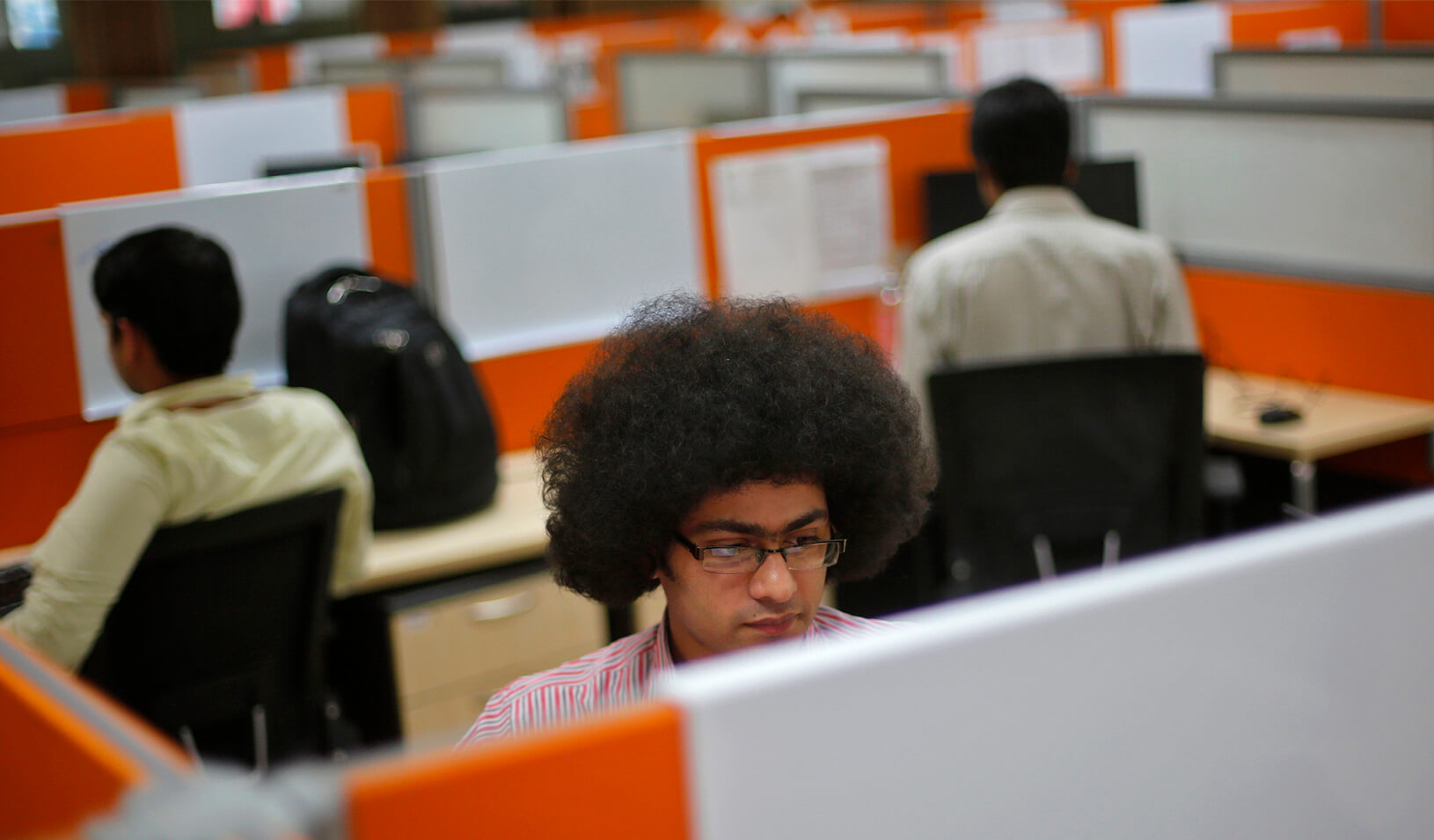 People intently working in cubicles