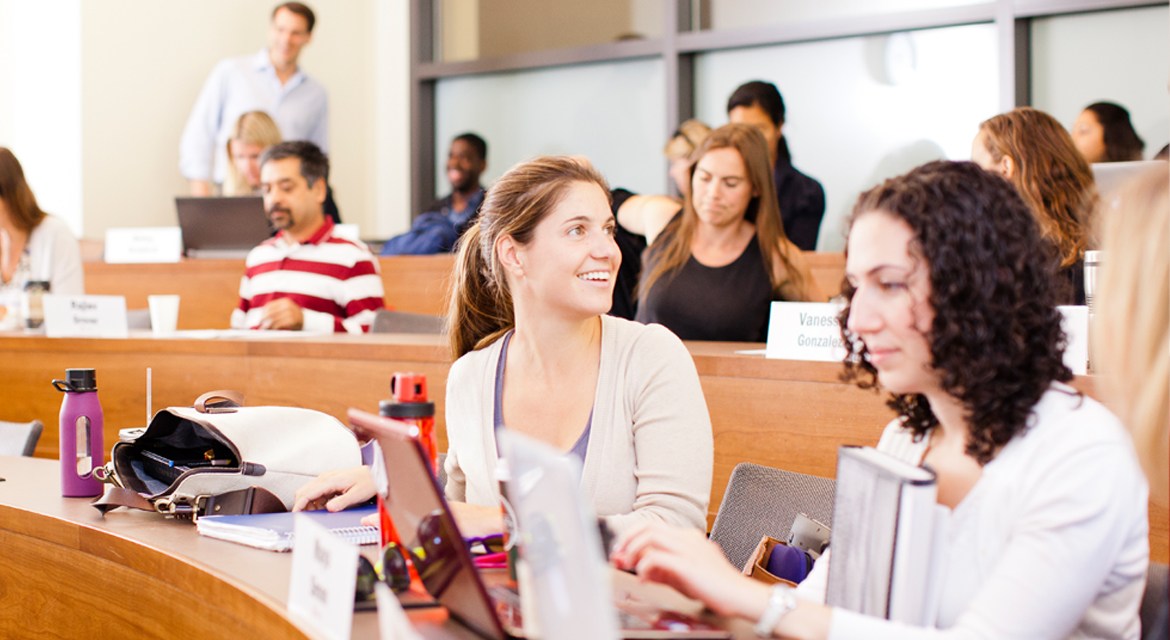 Female student in class talking with someone behind her