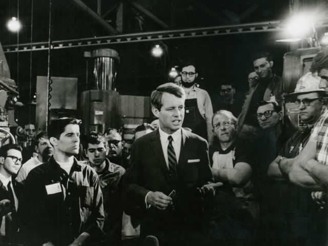 Attorney General Robert F. Kennedy talks with laborers.