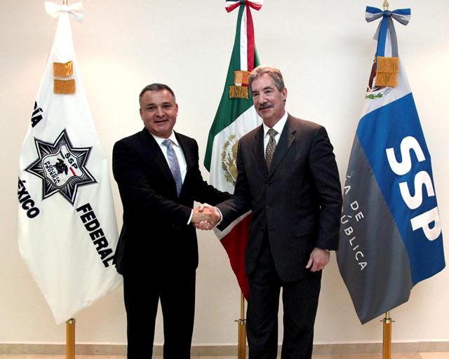 Deputy Attorney General James Cole and Mexican Secretary of Public Security Genaro Garcia Luna standing shaking hands