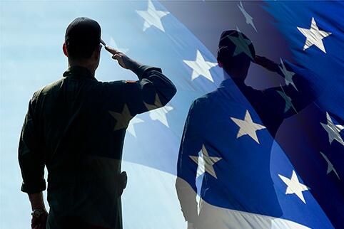 Person standing in salute with their reflection in a portion of the American flag.