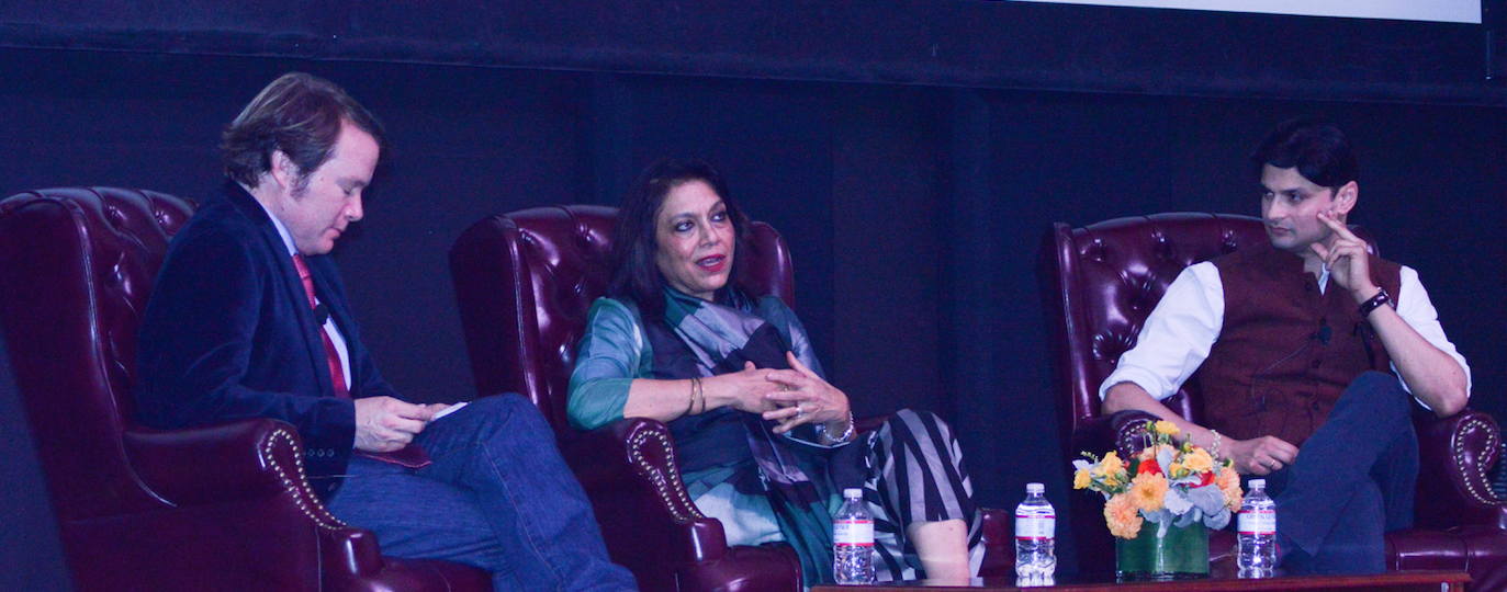 Three people seating on stage in conversation.