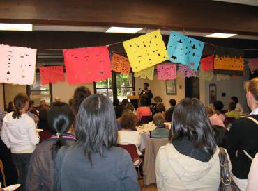 Audience members watching a speaker at an International Women's Day celebration