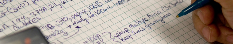 Close up of a Biosciences student writing in a lab notebook