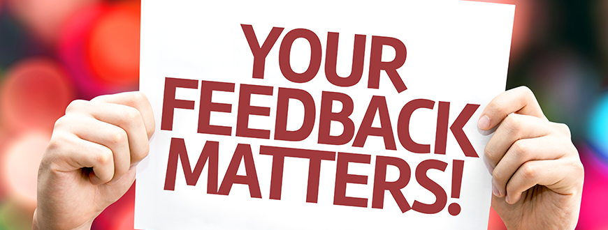 Person holding sign labelled "Your Feedback Matters1"