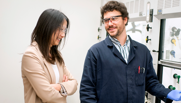 Female faculty member talking with male postdoc in lab