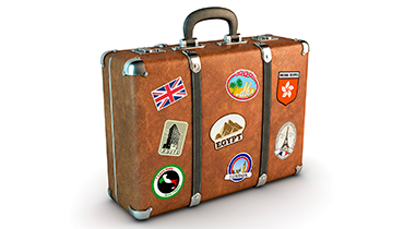Suitcase with different stickers of travel locales