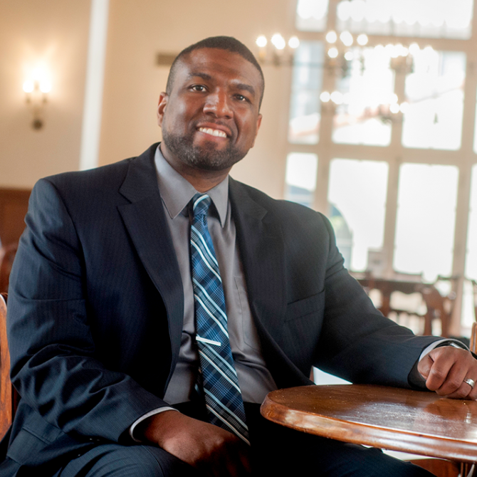 Portrait of African American staff member Kahlil Wells, sitting in Lakeside dining hall