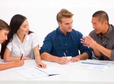 group of college students talk at a table