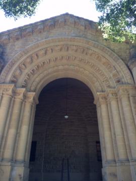 building entrance with large wooden door and decorated, arched entryway