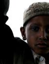 young Muslim boy stands in doorway