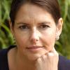 woman with brown hair pulled back looking thoughtful