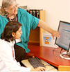 A librarian pointing at computer screen for a medical student