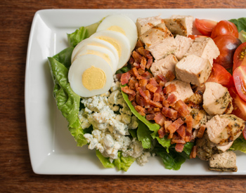 Olives catering includes fresh salad like this cob salad with bacon and chicken