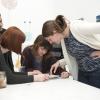 Male and female students bending over a table, examining something together