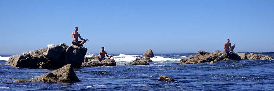Students meditate on rocks in the Monterey Bay. Photo by Sam Girvin.