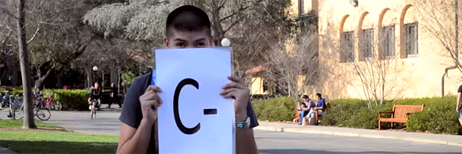 Student holding a card that says C minus.