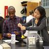 Two students in the Leland Scholars Program at Stanford University measure liquids in a chemistry lab.