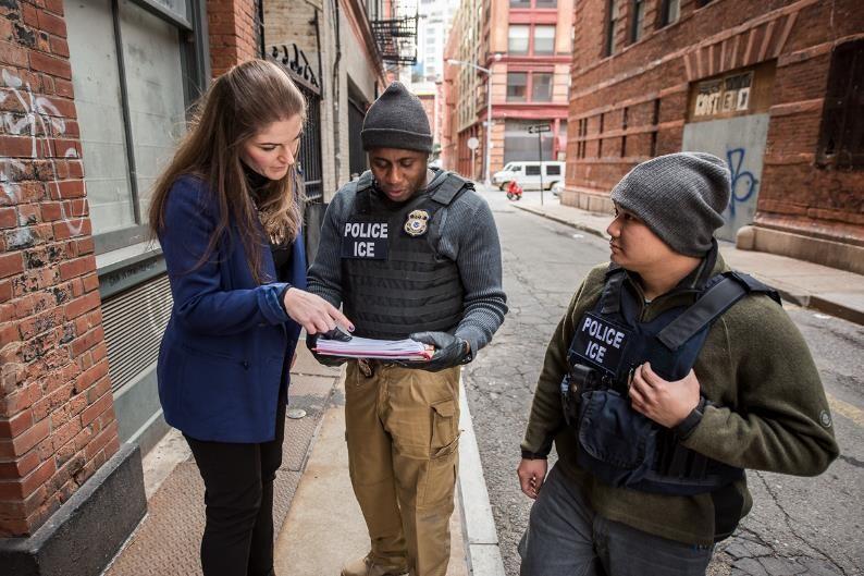 ICE employees consulting over paperwork