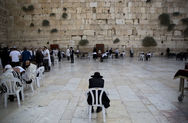 Ultra-Orthodox Jewish men participate in a morning prayer, in front of the Western Wall, the holiest site where Jews can pray in Jerusalem's Old City, Monday Oct. 12, 2015. (AP Photo/Oded Balilty)