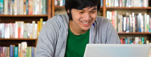 Knowledge Central mini banner - Asian American student on laptop in library.