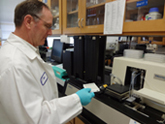 diagnostic lab personnel taking samples to machine