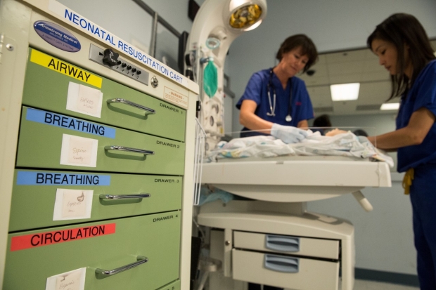 Neonatal Resuscitation Cart in the foreground, and in the background a resuscitation simulation.