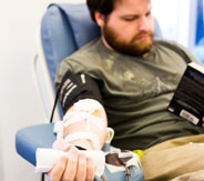 Galen Poulton enjoys a book while donating platelets.