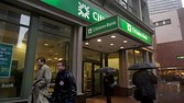 Pedestrians carrying umbrellas pass in front of a Citizens Financial Group Inc. bank branch in Boston, Massachusetts, U.S., on Wednesday, Feb. 27, 2013. Royal Bank of Scotland Group Plc will this week announce plans to sell a stake in Citizens Financial Group Inc. and shrink assets at its investment-bank by as much as 30 billion pounds, said a person with knowledge of the plans, who asked not to be identified because the matter is private. Photographer: Kelvin Ma/Bloomberg