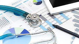 Stethoscope sitting on top of printed chart and graphs