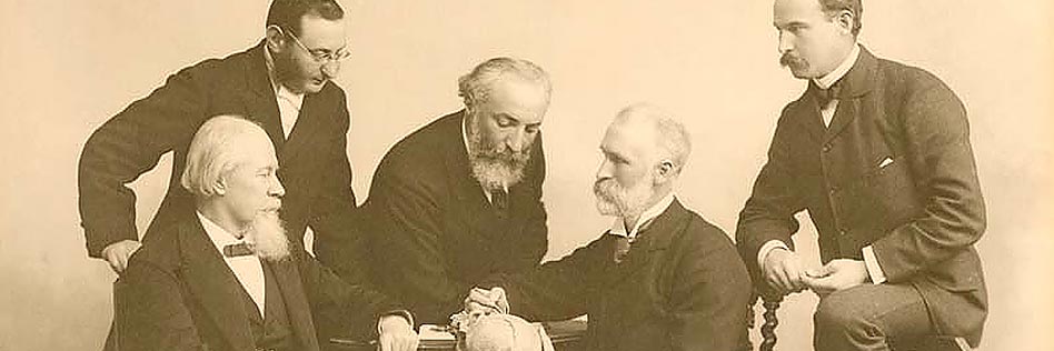 A group photo of Sir William Macewen (1848-1924) with Adolph Barkan (1845-1935), Stanley Stillman (1861-1935). Levi Cooper Lane (1828-1902), Joseph Oakland Hirschfelfer (1854-1920) demonstrating Macewen's triangle