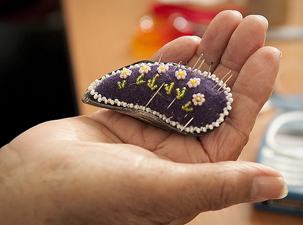 Alaskan native Mabel Pike holds a shell with a beaded pincushion she made as she taught students at the Native American center. Students cut, stitched and beaded traditional moccasins in the course of a week.
