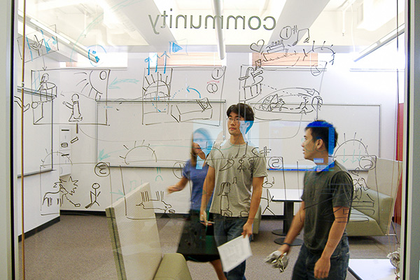 Students in front of line drawings on board. 