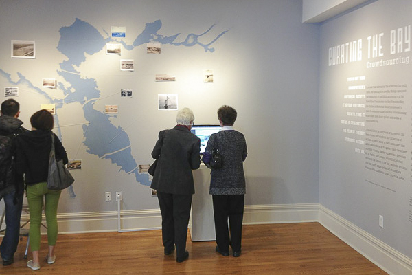 Visitors explore the Year of the Bay virtual history map at the California Historical Society exhibition 'Curating the Bay.' 