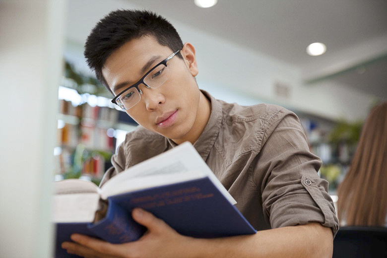 student studying a textbook / Dean Drobot/Shutterstock
