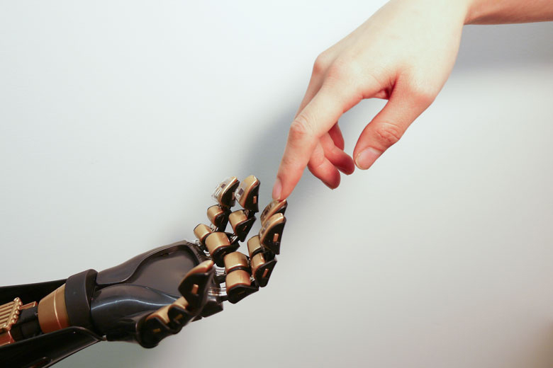 Human hand touching mechanical hand