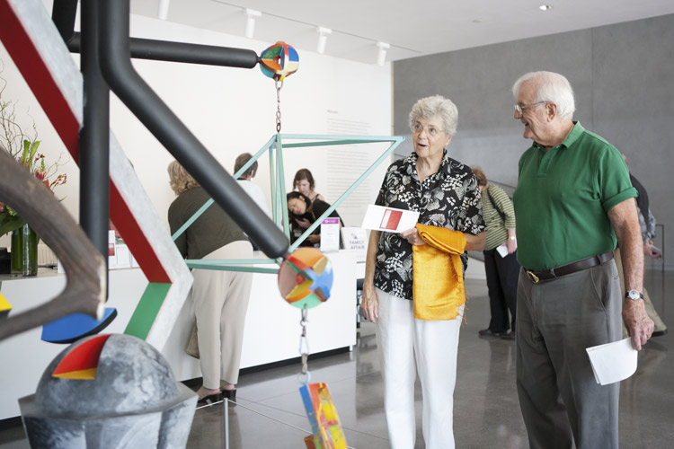 Photo of a couple looking at a sculpture titled Plumb Bob in the lobby of the Anderson Collection at Stanford University