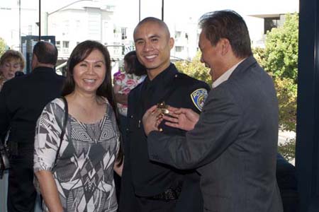 Officer Phi Le at his graduation with his parents.