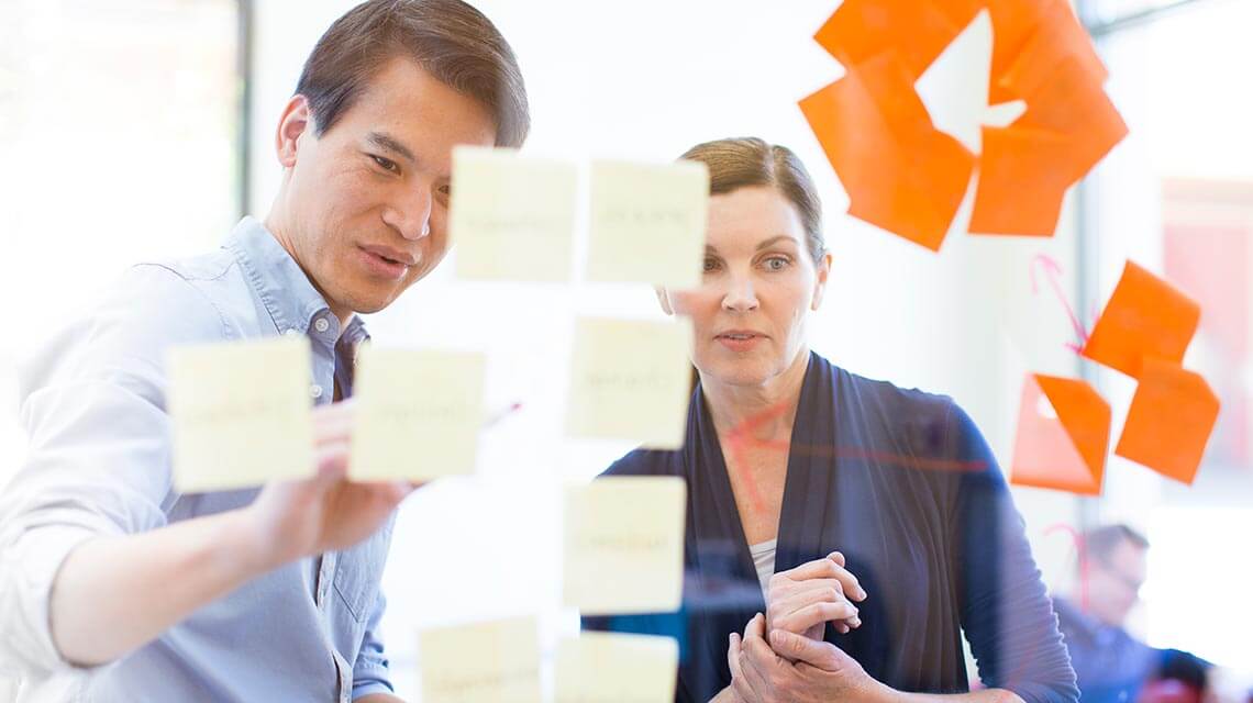 Participants in a Design Thinking workshop looking at post-its