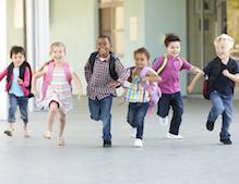 Small children running in school hallway