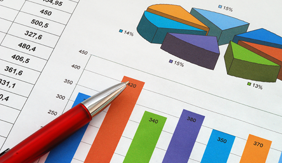 Red pen on paper showing colorful pie chart and bar graph