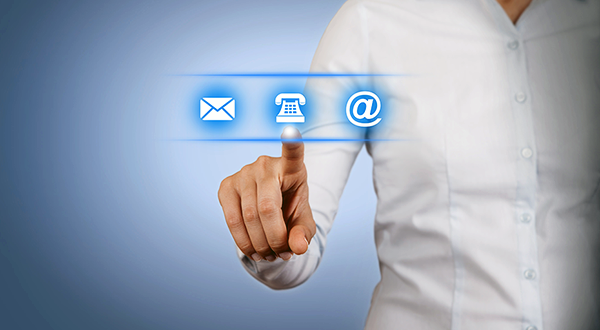 Business professional pointing to touch screen with mail, phone and email icons