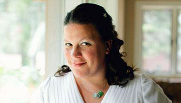 Portrait of staffer Csilla Csaplár inside, with foliage through windows in background