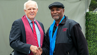 Honoree Ray McKee shakes hands with President John Hennessy