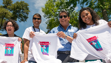 Staff volunteers help distribute T-shirts at the Multicultural Springfest.